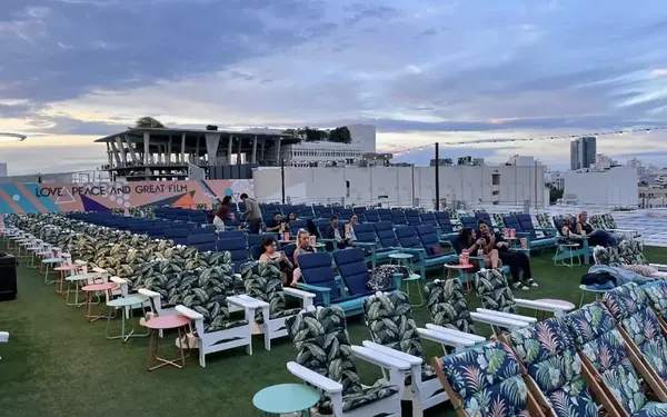 People sitting at Rooftop Cinema Club South during sunset
