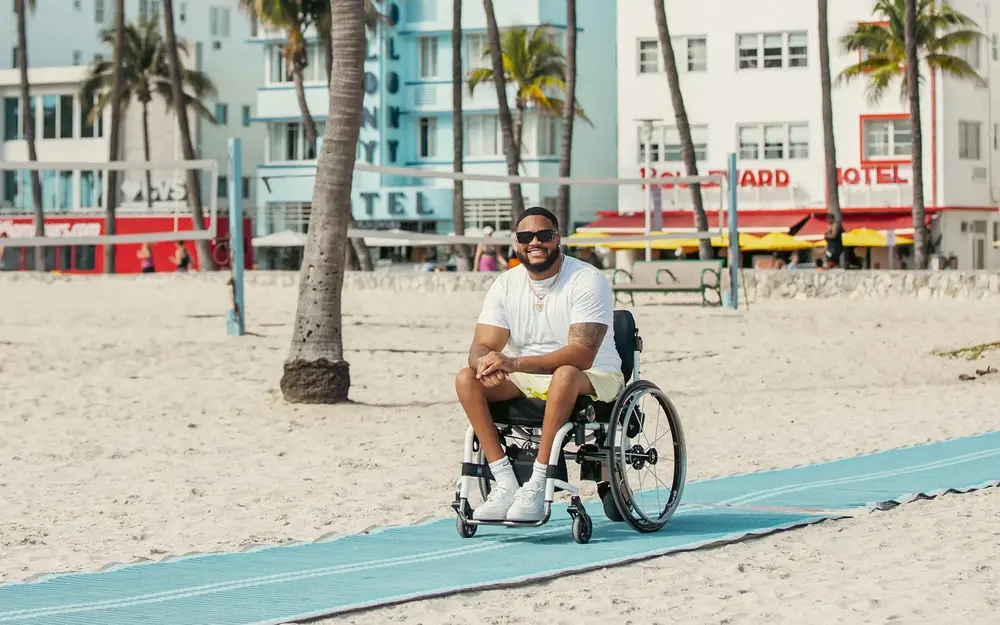 Accessible visitor in wheelchair on South Beach beach mat