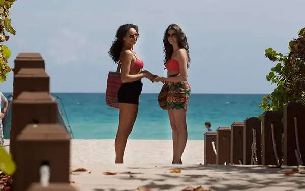 Two girls together on a beach walkway.