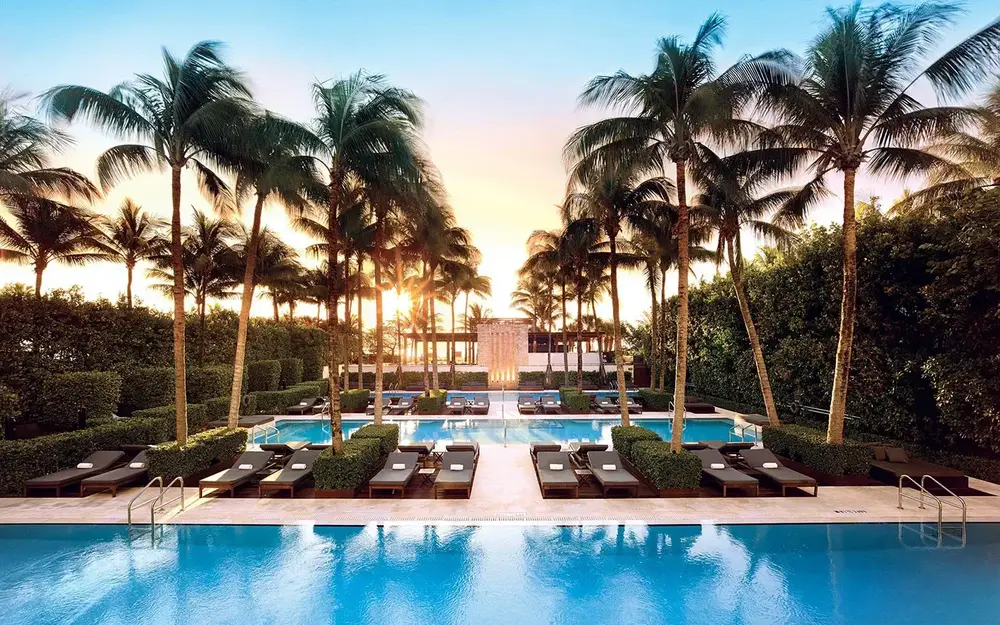The Setai poolscape with the sun setting in through the trees