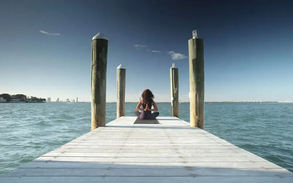 Woman in a yoga pose by the ocean at The Standard Spa