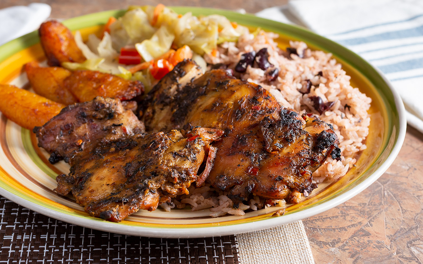 Jerk chicken with rice, plantains and greens