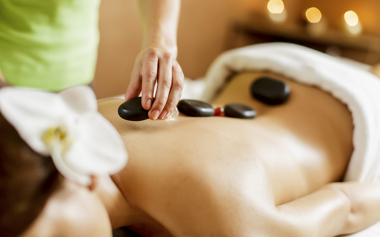 Mulher desfrutando de uma massagem com pedras quentes