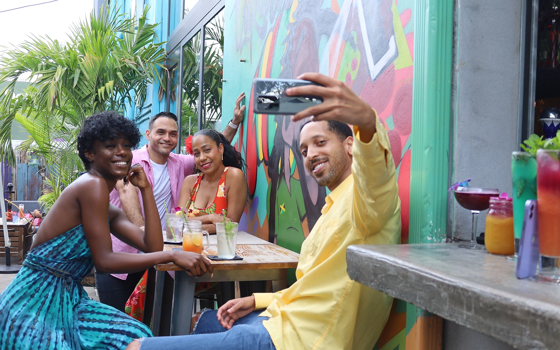 Friends posing for a selfie with cocktails