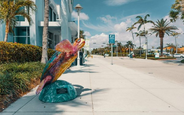 歩道を飾る巨大なカラフルなカメの彫刻Surfside