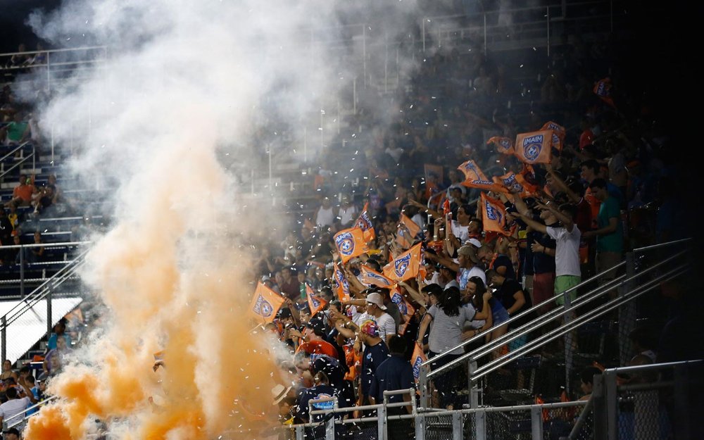 マイアミ FC ファンの上に紙吹雪とオレンジ色の煙