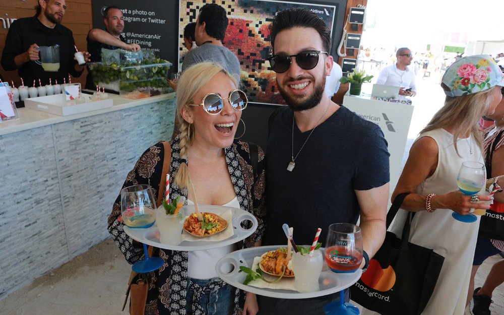 Pareja posando con su comida y bebida en SOBEWFF®