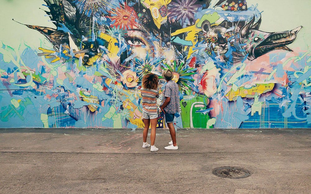 Casal admirando um mural em Wynwood Walls