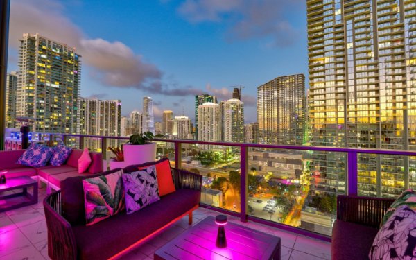 Una acogedora zona de estar en el balcón del Rosa Sky, que ofrece impresionantes vistas del horizonte de Miami.
