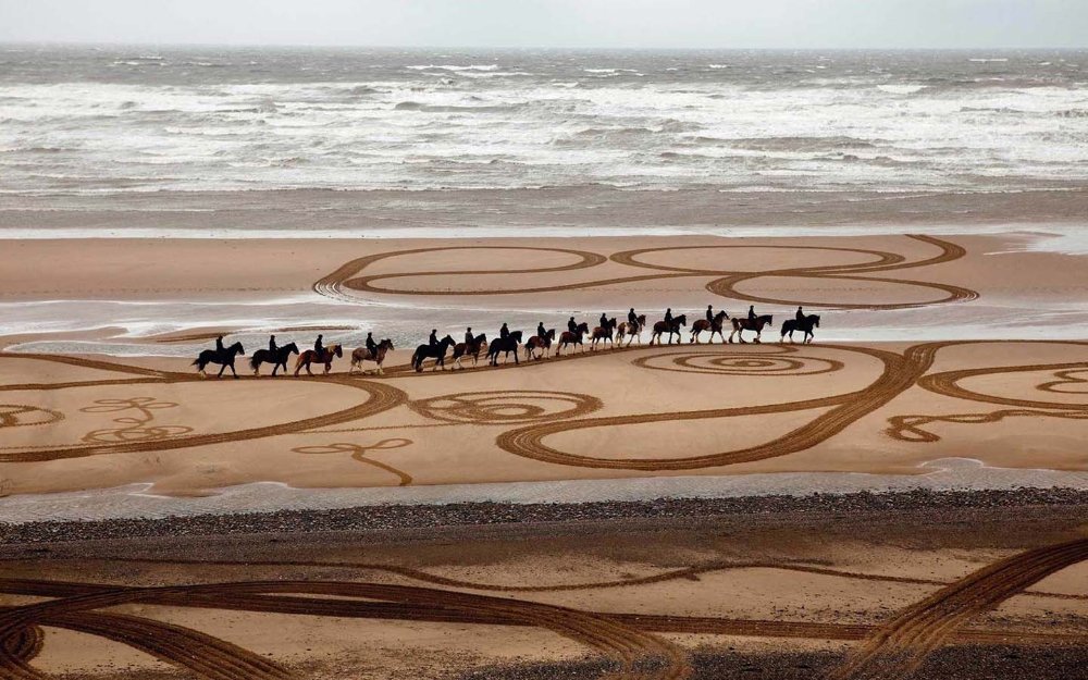 伊芙·赖特 (Eve Wright) 创作的马匹与骑手沿着海滩的艺术作品