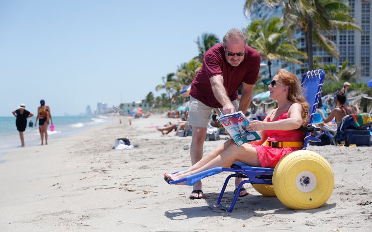 Woman reading on the beach on a Joy on the Beach Wheelchair, photo by Special Needs Group® / Special Needs at Sea® Woman reading on the beach on a Joy on the Beach Wheelchair, photo by Special Needs Group® / Special Needs at Sea®