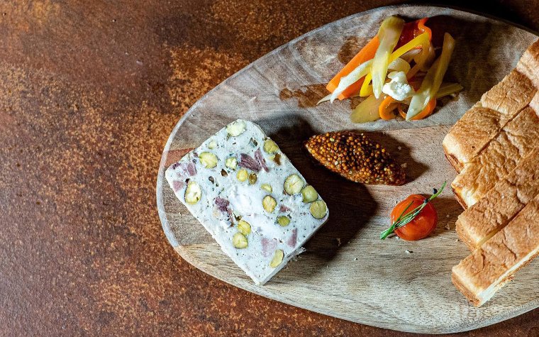 Charcuterie board with meats and garnishes at Ariete