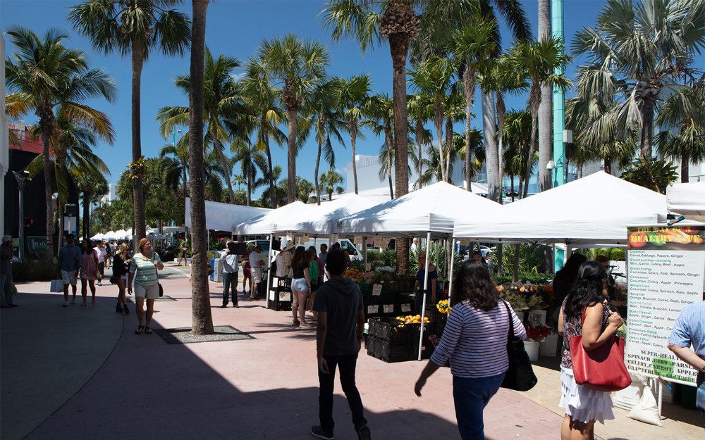 Moun k ap mache pa tant machann nan Lincoln Road Farmers Market