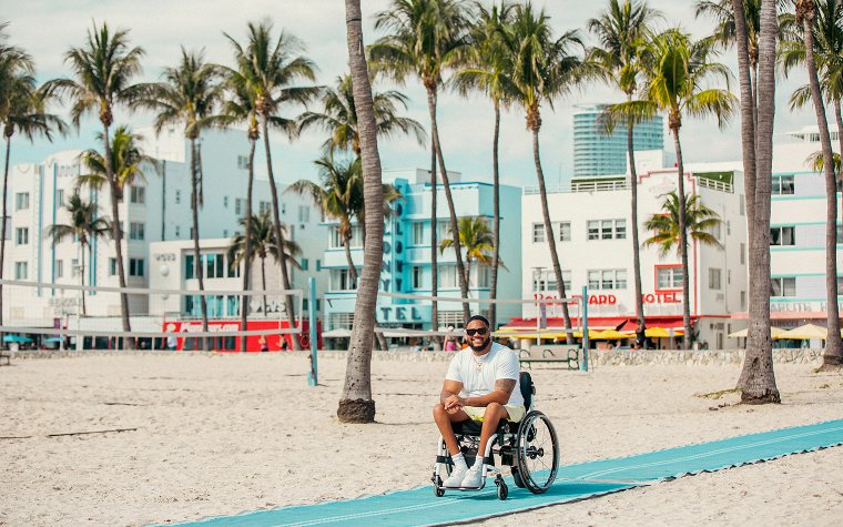 Man in a wheelchair on the beach access point, photo by Wheel the World Man in a wheelchair on the beach access point, photo by Wheel the World