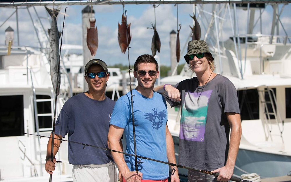 Grupo de fretamento de pesca exibindo suas capturas