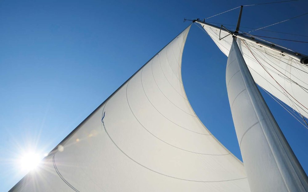 View of sailboat's white sails from deck View of sailboat's white sails from deck