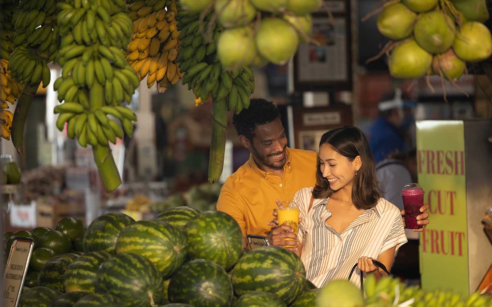 Casal fazendo compras na barraca de frutas Robert Is Here. 