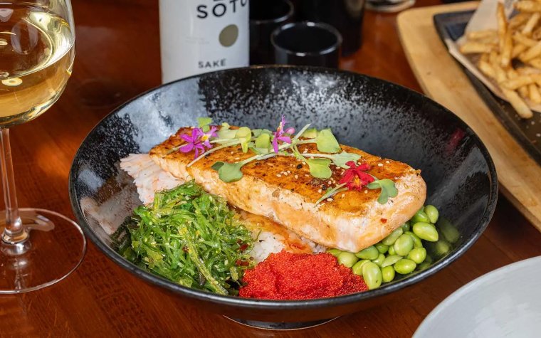 Salmon poke bowl with vegetables and garnish