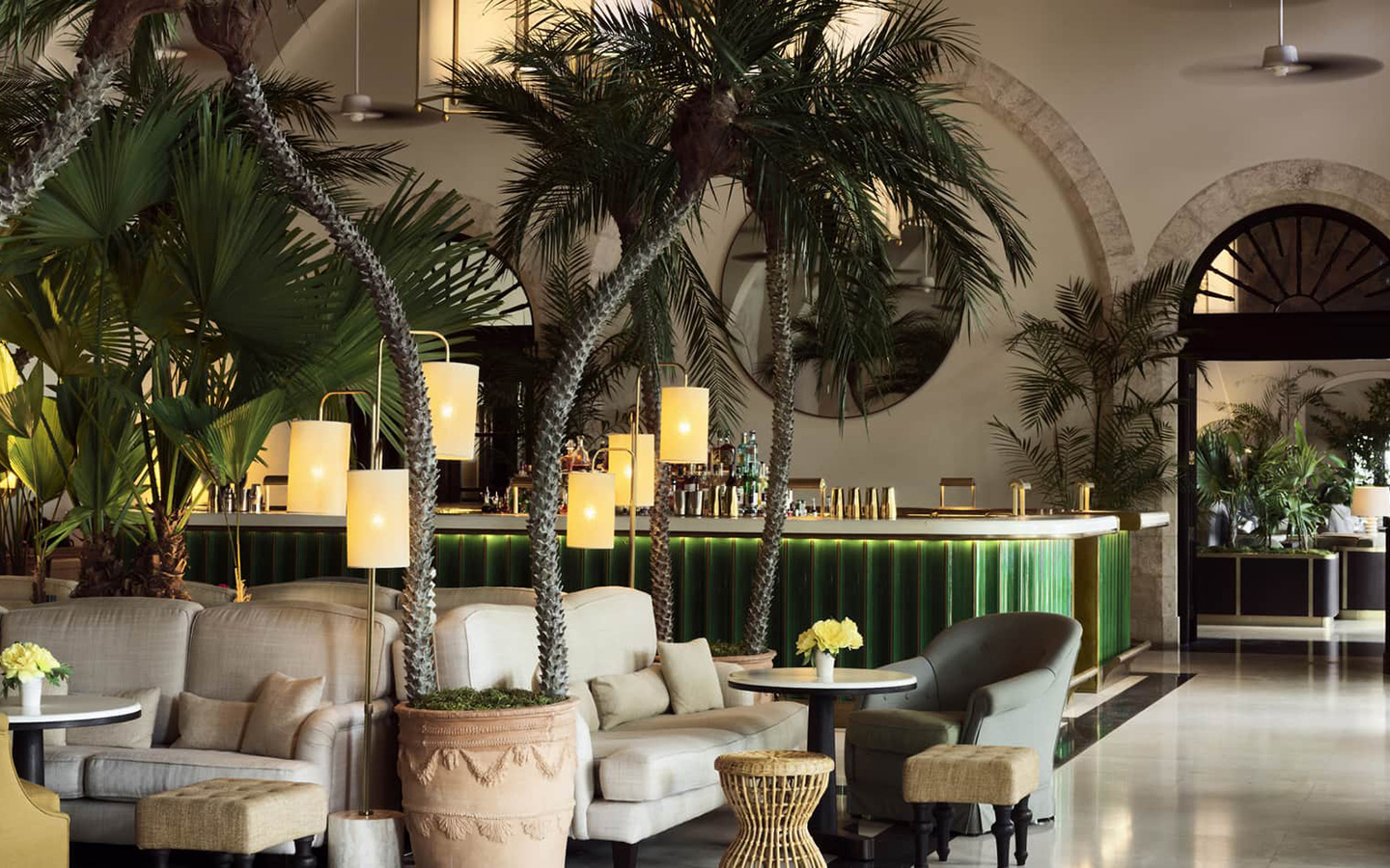 Sitzbereich der Champagne Bar unter Palmen mit Bar im Hintergrund