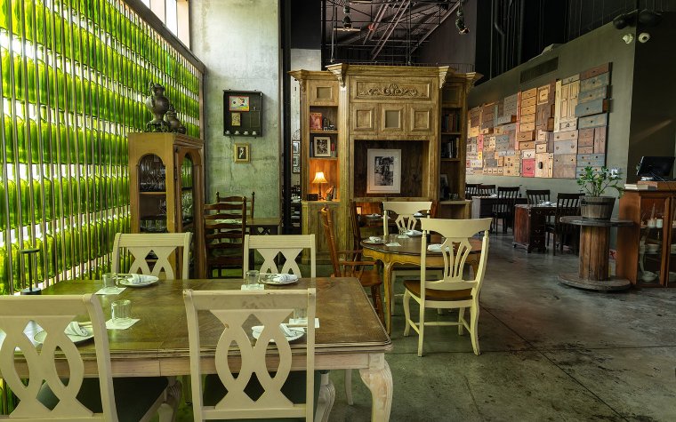 Bunbury green seating with book-lined walls and eclectic decor