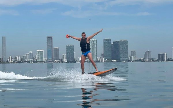 Ravi Roth surft mit Blick auf die Skyline von Downtown Miami