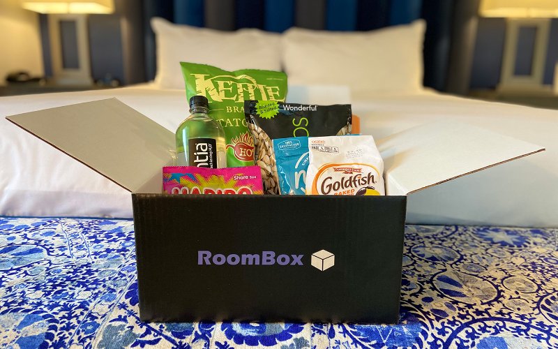 Roombox basket with food and drink on a hotel bed