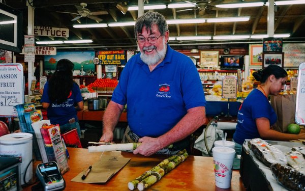 Robert prepara la canna da zucchero presso Robert is Here Fruit Stand and Farm