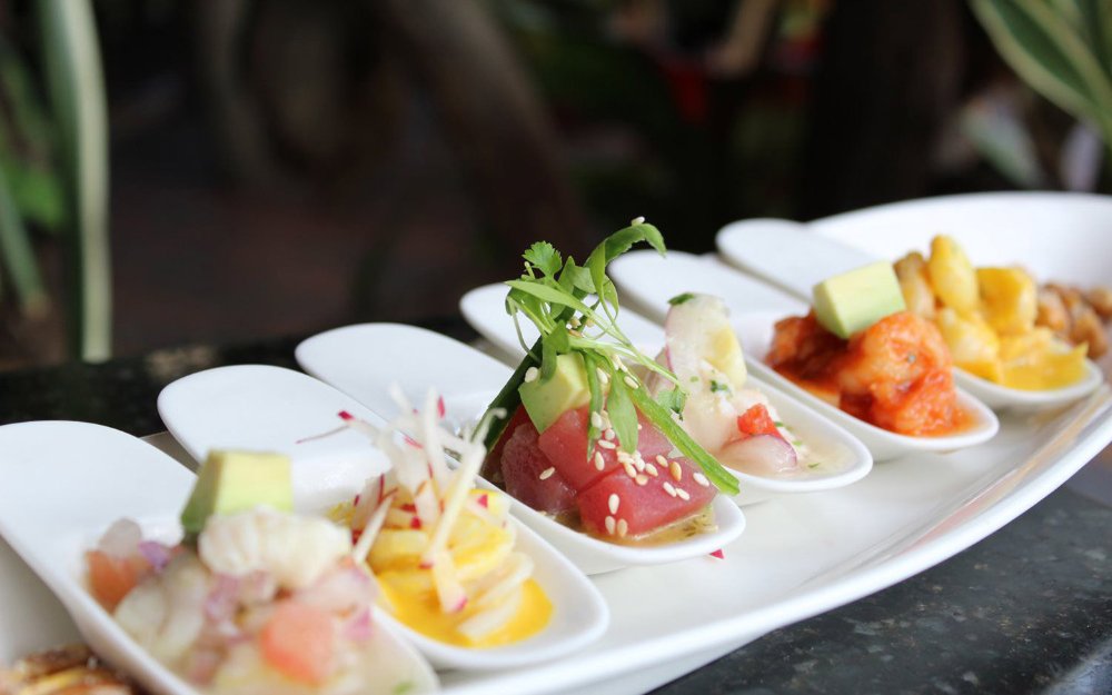 Una variedad de ceviche en cucharas de degustación en Jaguar