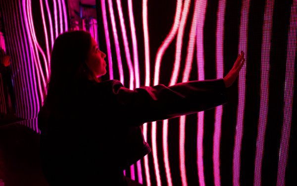 Woman interacting with art at Magentaverse at Artechouse
