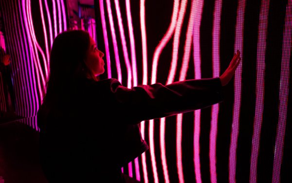 Mujer interactuando con el arte en Magentaverse en Artechouse