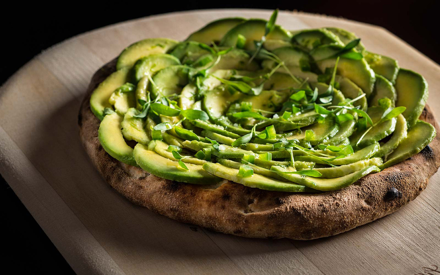 Crispy pizza topped with avocado slices Crispy pizza topped with avocado slices