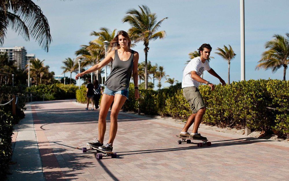 Couple skateboarding on South Beach