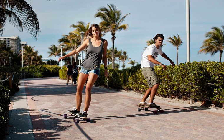 Couple skateboarding on the Beachwalk Couple skateboarding on the Beachwalk