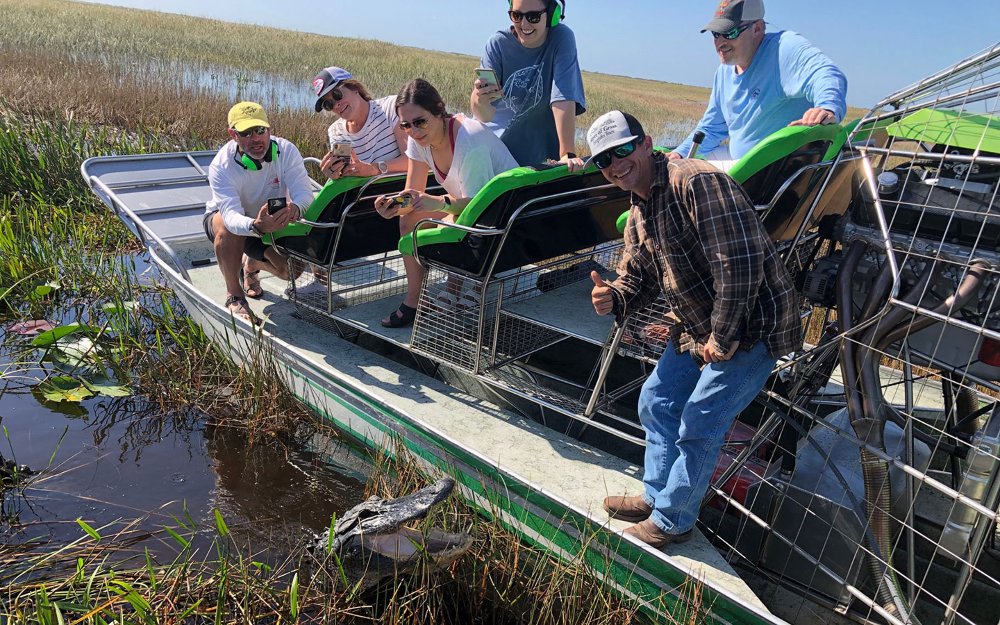 Airboat in the Everglades with an alligator visible in the water
