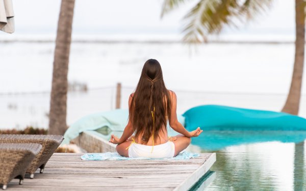 Girl doing yoga on a deck with an ocean view