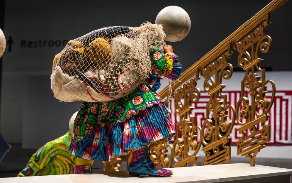 Escultura Moving Up de Yinka Shonibare que representa a personas subiendo escaleras, cortesía de Art Basel