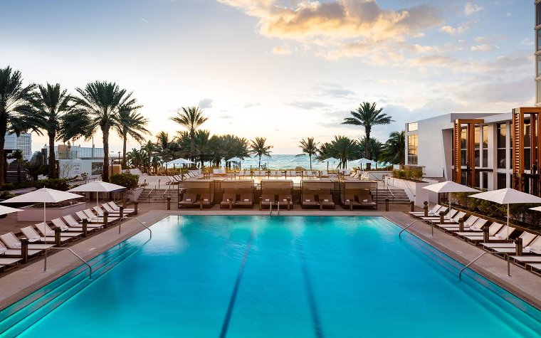 Oceanside pool area with loungers at Nobu Eden Roc
