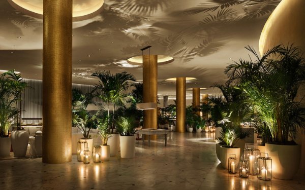 Lámparas de huracán brillando en el vestíbulo dorado de The Miami Beach EDITION