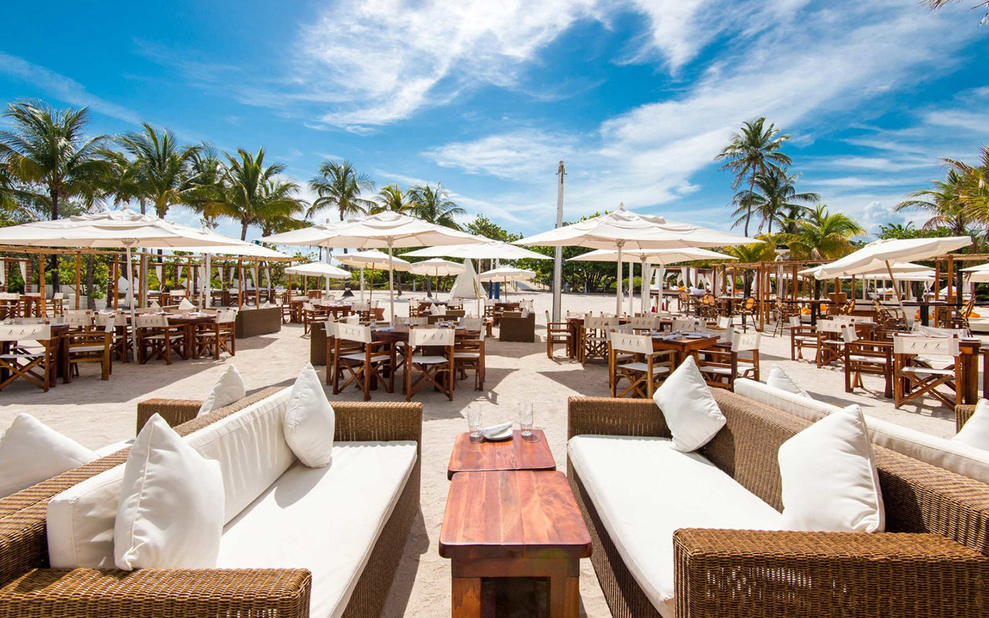 Outdoor table setup with white linens and umbrellas at Nikki Beach Outdoor table setup with white linens and umbrellas at Nikki Beach