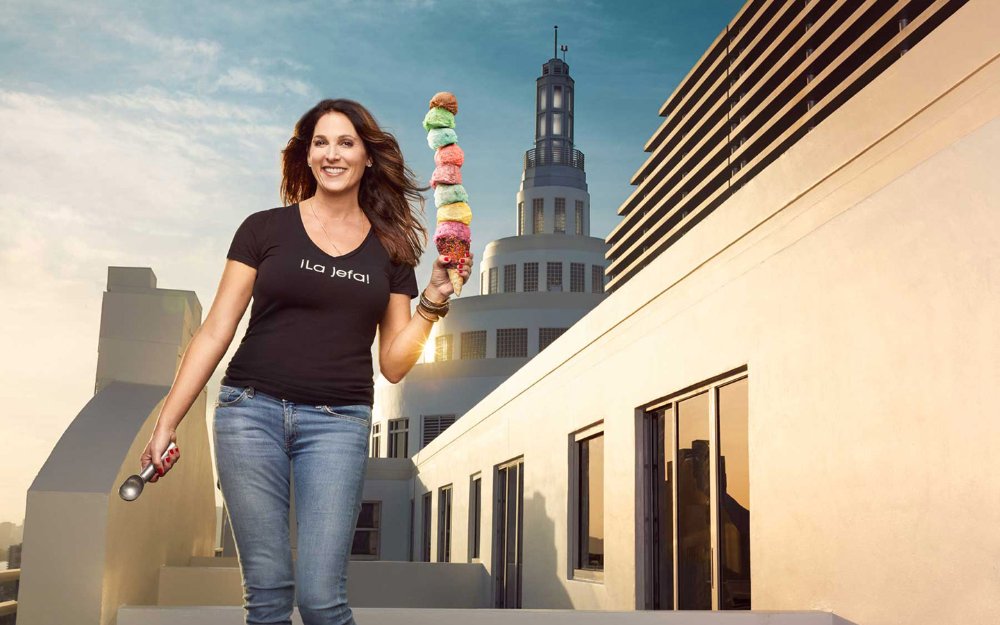 Woman holding an ice cream cone stacked high with scoops from Azucar Ice Cream