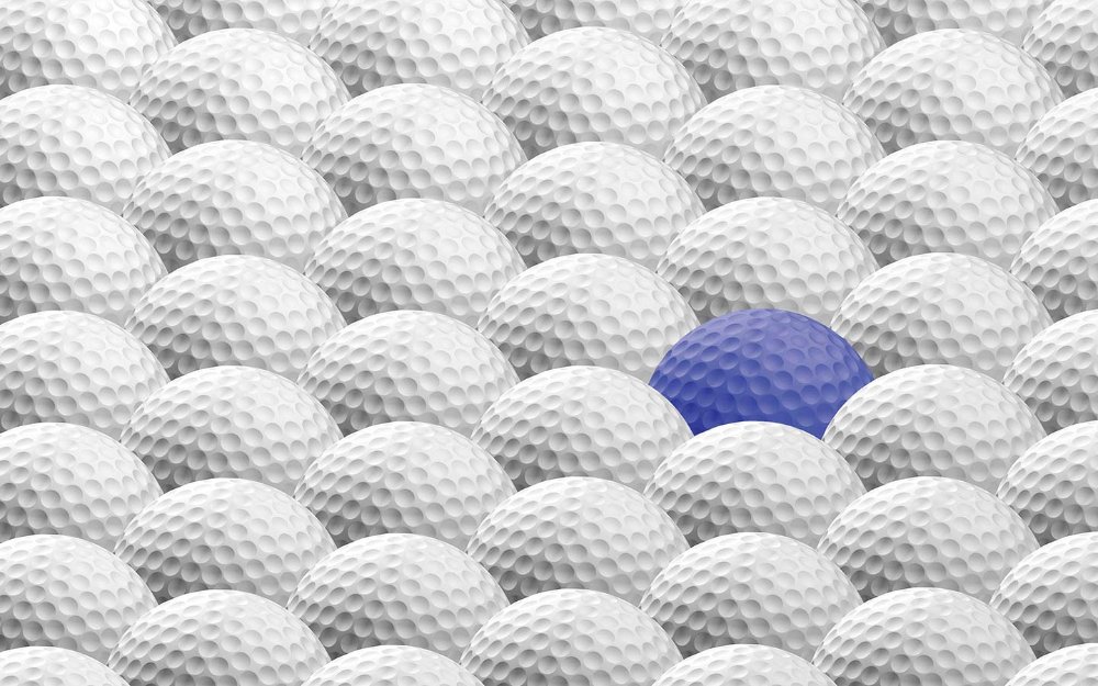 Один синий мячик для гольфа среди белых