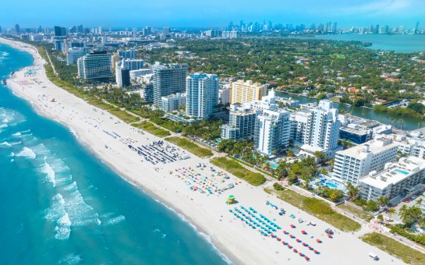 Vista aérea da água azul cintilante e das areias brancas de Miami Beach