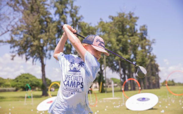 Menino balançando um clube de golfe