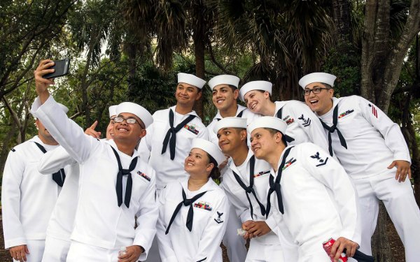 Imagem de um grupo com uniformes da Marinha tirando uma selfie