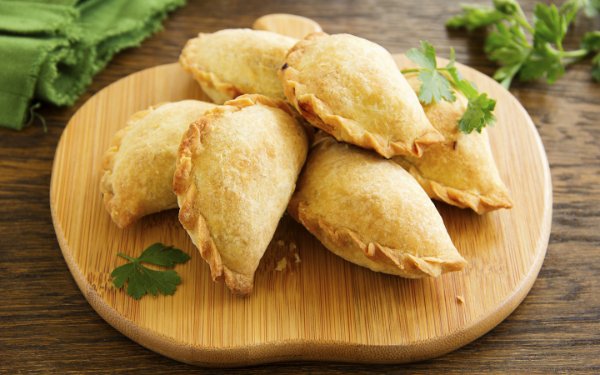 Empanadas apresentadas em tabuleiro entalhado