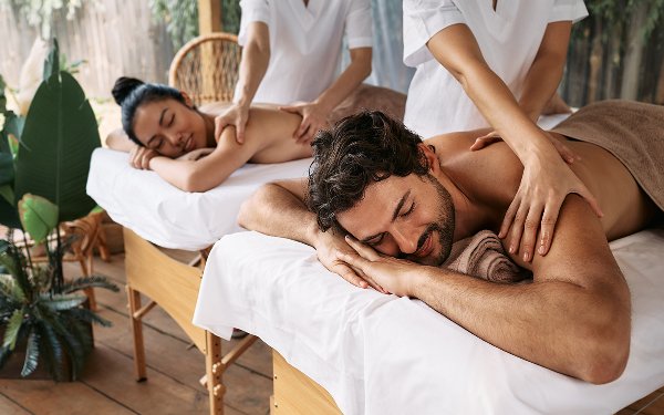 一对夫妇在水疗中心并肩接受按摩