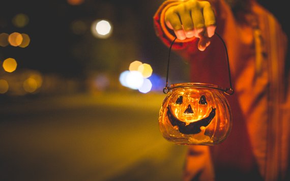 Kind, das Jack-o'-Laternenlicht hält