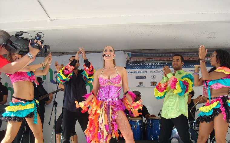 Performers on stage at Calle Ocho Festival, dazzling in bright, colorful outfits Performers on stage at Calle Ocho Festival