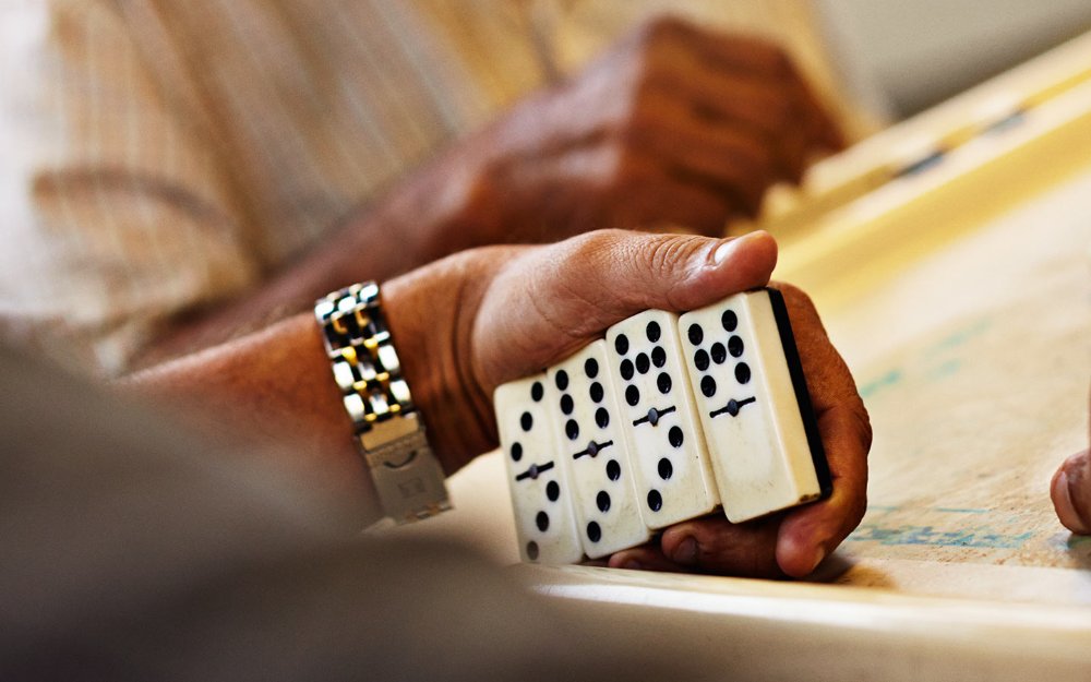 Jogador verificando suas peças de dominó