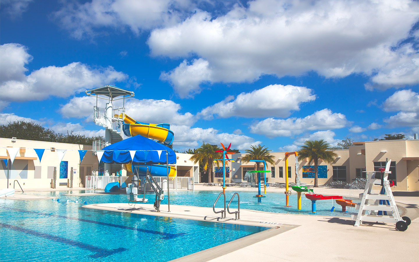 Miami Springs Aquatic Center featuring a large pool area with a fun water slide and inviting swimming facilities Miami Springs Aquatic Center featuring a large pool area with a fun water slide and inviting swimming facilities
